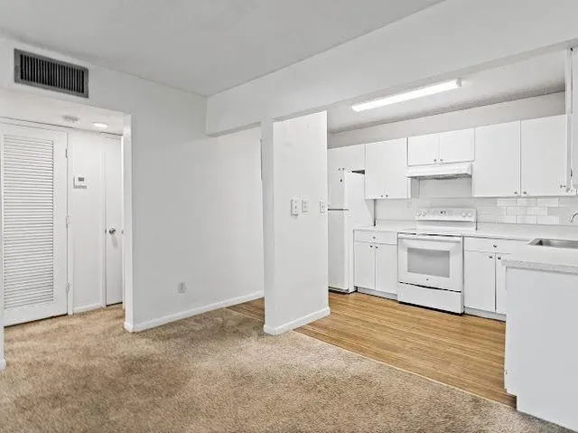 a kitchen with white cabinets and white appliances