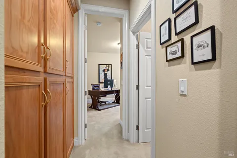 a view of staircase with lots of frames on wall and wooden floor