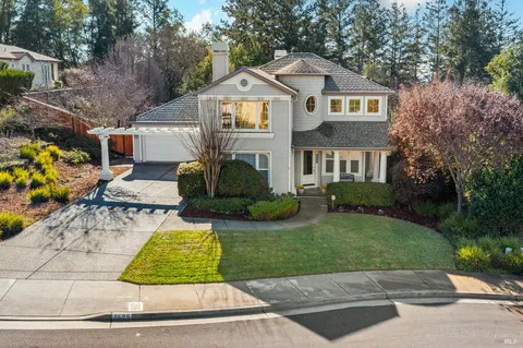a kitchen with stainless steel appliances granite countertop a refrigerator a sink a stove a dining table and chairs