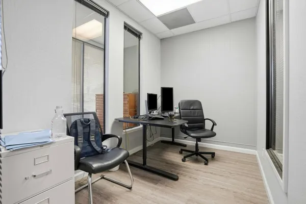 a view of a workspace with furniture and a window