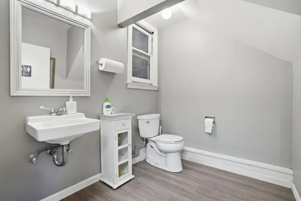 a view of a hallway with a livingroom and a bathroom with mirror