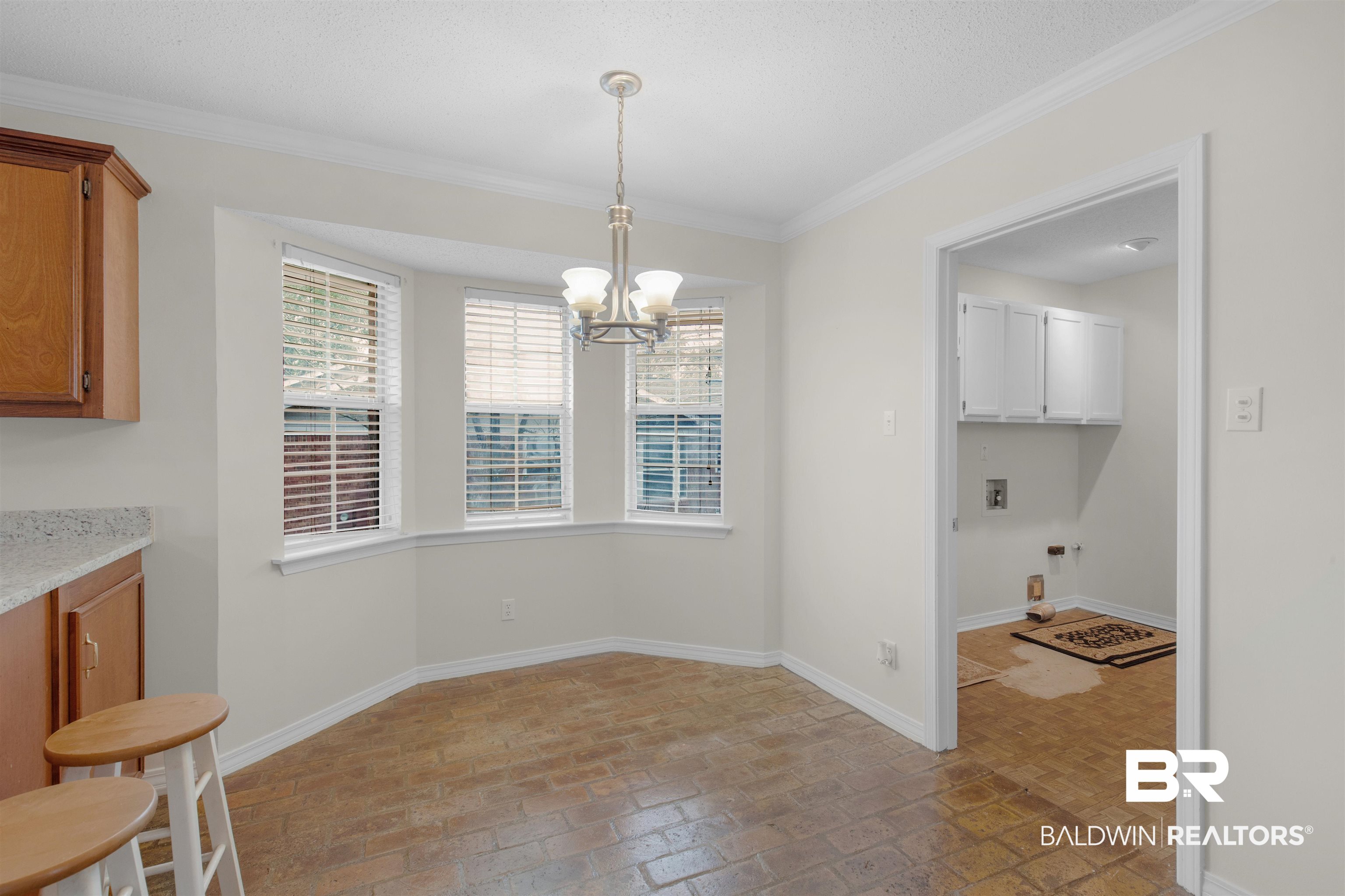 7225 Smithfield Road East Mobile, AL 36695 - Photo 7 of 27 Dining area with a chandelier, brick floor, crown molding, and baseboards