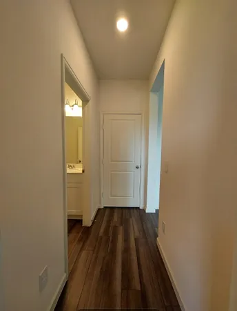 a view of a room with wooden floor white walls and staircase