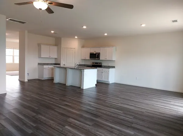 a kitchen with stainless steel appliances wooden floors and view living room