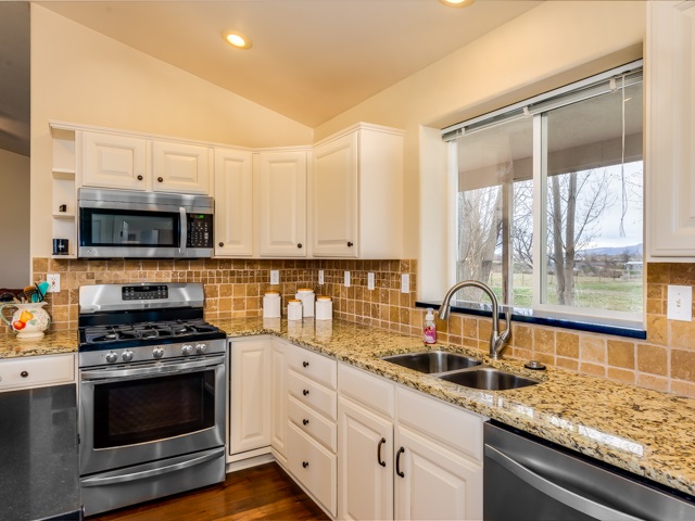 1677 L Road Fruita, CO 81521 - Photo 11 of 42 a kitchen with granite countertop a stove and a sink