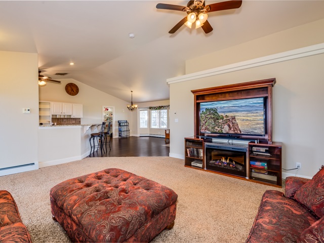 1677 L Road Fruita, CO 81521 - Photo 15 of 42 a living room with furniture and a flat screen tv with kitchen view