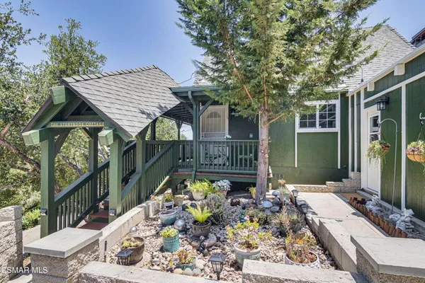 a view of a patio with table and chairs potted plants with wooden floor and fence