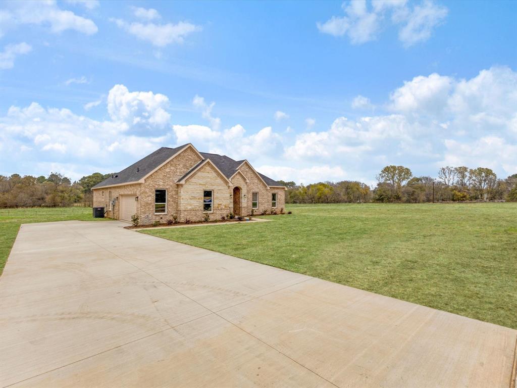 544 Shepherd Road Combine, TX 75159 - Photo 4 of 36 View of front of home featuring a front yard, stone siding, concrete driveway, and an attached garage