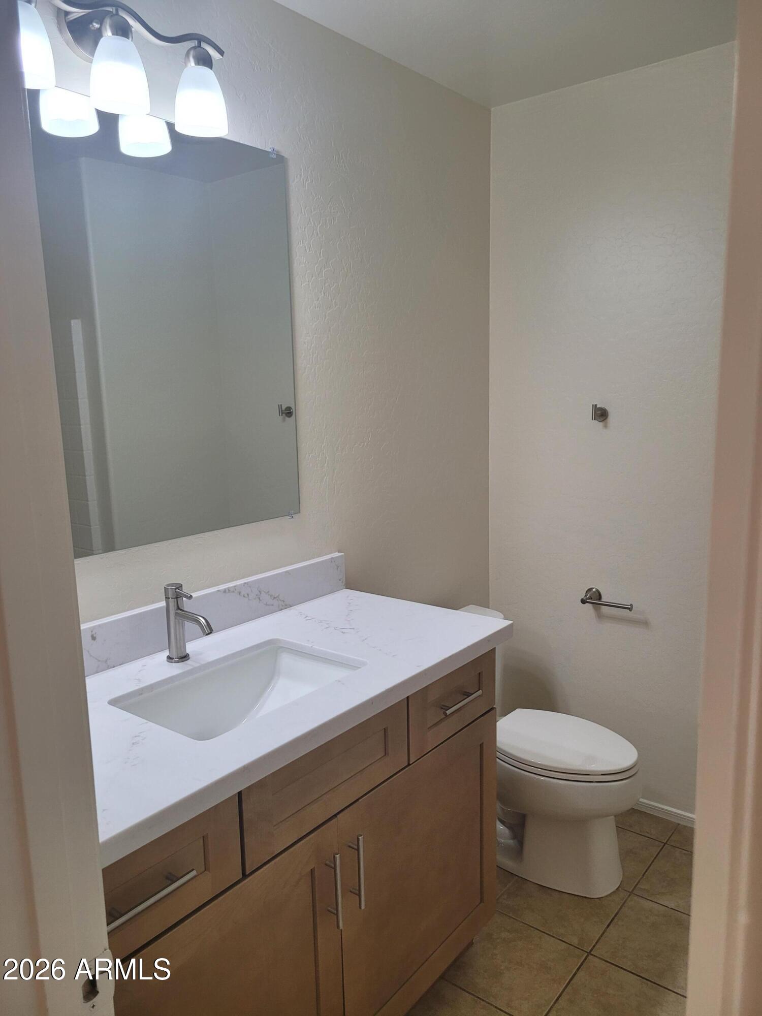 1453 South Sinova Avenue Gilbert, AZ 85296 - Photo 34 of 46 a bathroom with a sink a toilet and a mirror