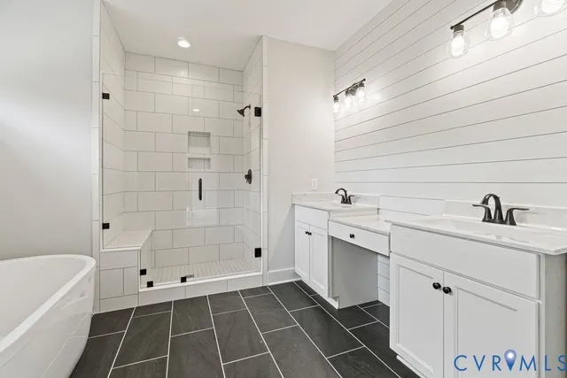 a bathroom with a double vanity sink a mirror and a bathtub