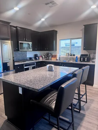a kitchen with granite countertop stainless steel appliances and wooden cabinets