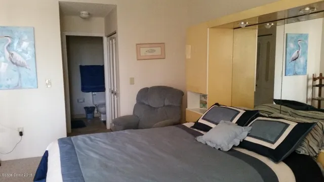 a bedroom with a bed and a mirror