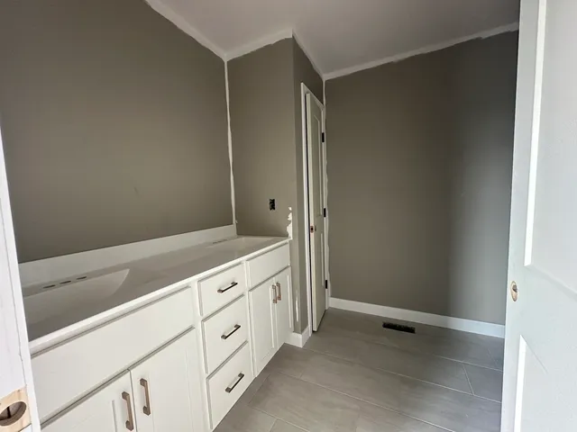 a view of a kitchen with white cabinets