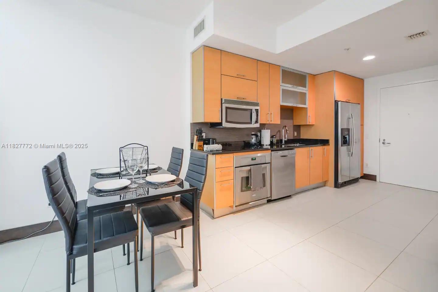 Brickell Miami, FL 33130 - Photo 11 of 26 a kitchen with stainless steel appliances kitchen island granite countertop a stove top oven a sink a dining table and chairs with wooden floor