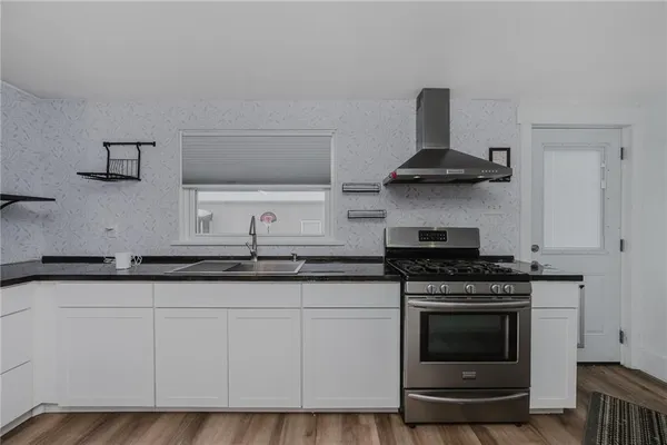 a kitchen with granite countertop a stove and a sink