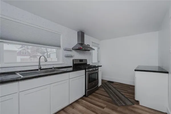 a kitchen with stainless steel appliances a sink stove and cabinets