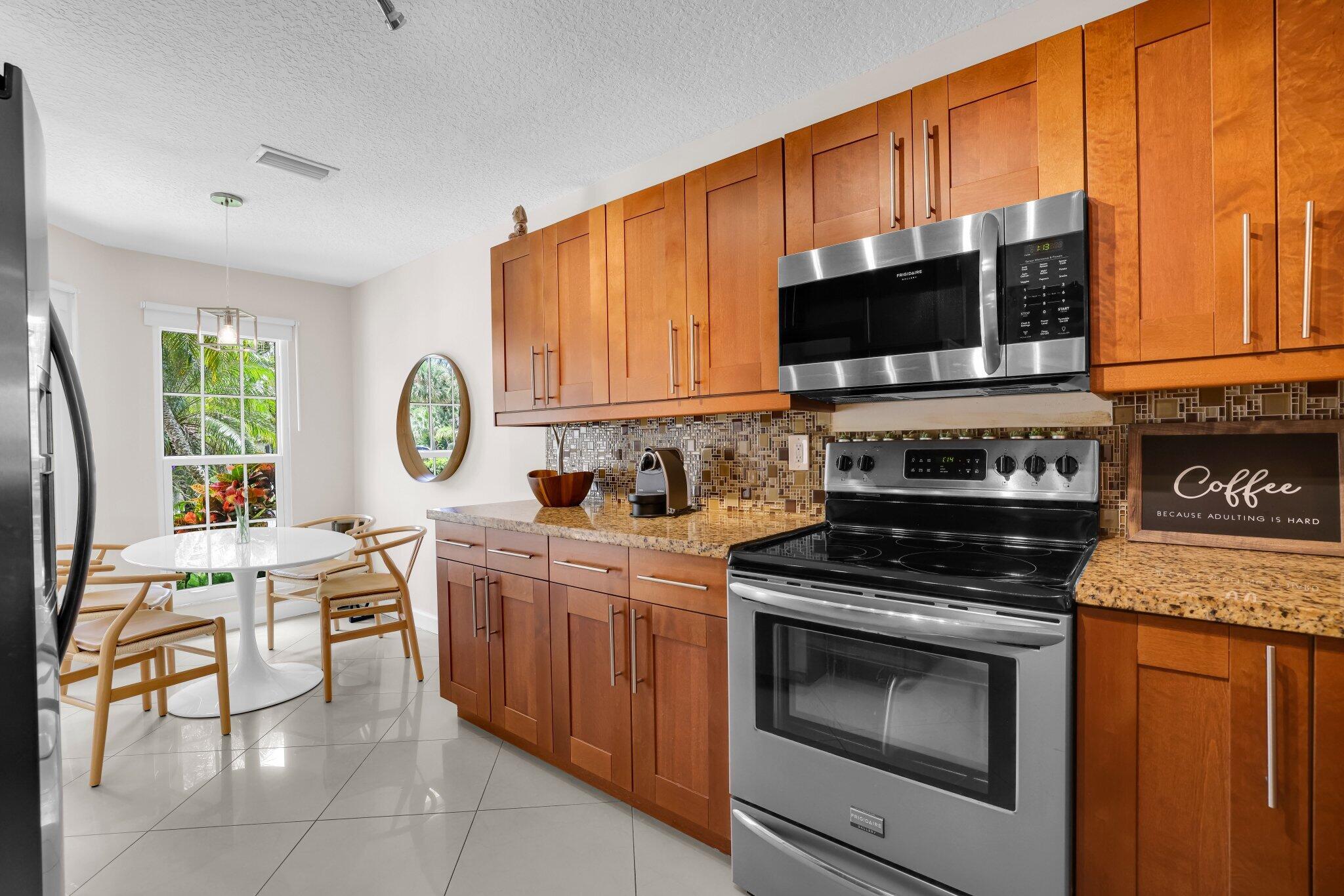 10323 Hidden Springs Court Boca Raton, FL 33498 - Photo 8 of 41 a kitchen with stainless steel appliances a stove a sink and a microwave