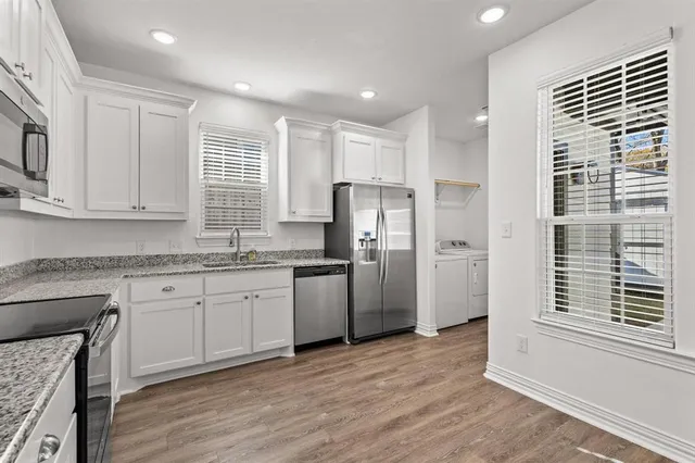 a kitchen with stainless steel appliances granite countertop a refrigerator and a stove top oven