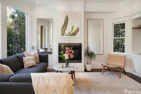 a living room with furniture large window and a fireplace