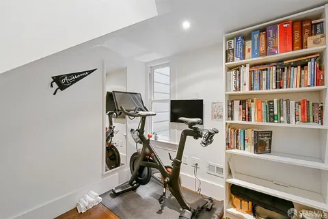 a view of a workspace with furniture and a bookshelf