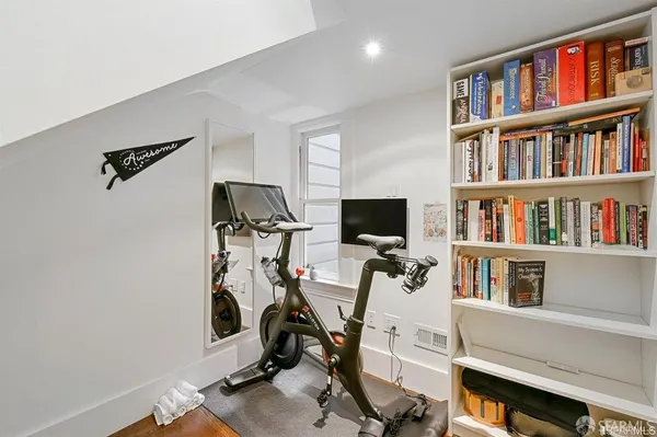 a view of a workspace with furniture and a bookshelf