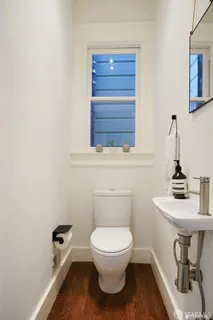 a bathroom with a toilet a sink and mirror