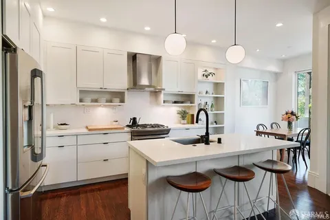a kitchen with granite countertop a sink cabinets and stainless steel appliances