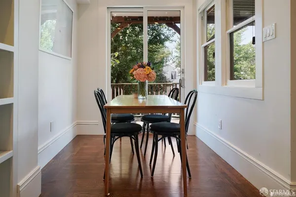 a dining room with furniture window and wooden floor