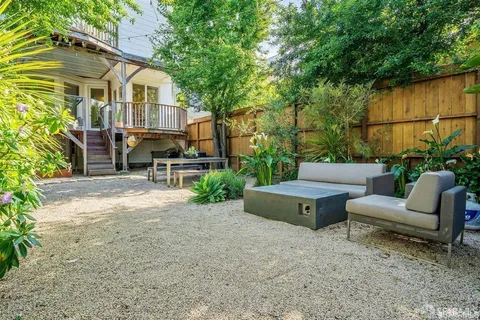 a view of a patio with couches table and chairs and potted plants