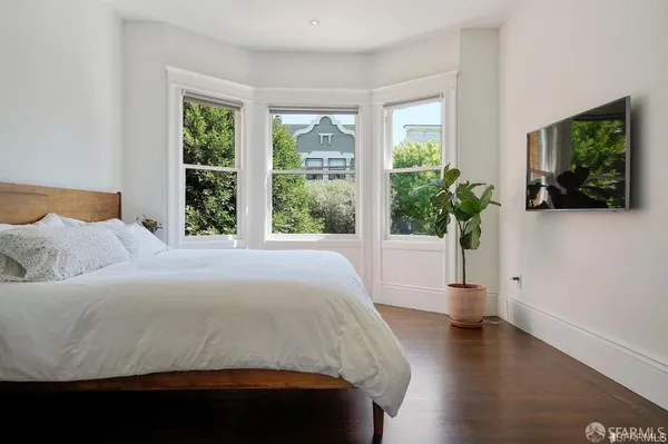 a bedroom with a bed and a large window