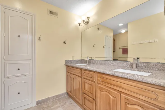 a bathroom with a granite countertop sink double and mirror