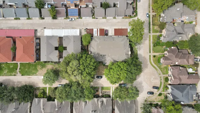 an aerial view of a house with a yard and large trees