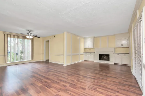 a view of empty room with wooden floor and fireplace