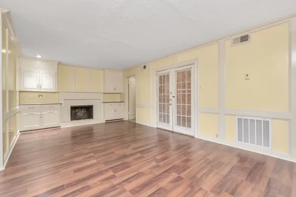 a view of a livingroom with wooden floor and a fireplace