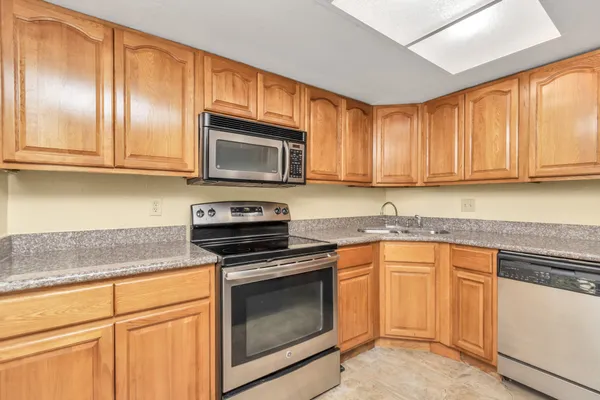 a kitchen with granite countertop cabinets stainless steel appliances and a sink