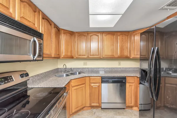 a kitchen with granite countertop stainless steel appliances and wooden cabinets