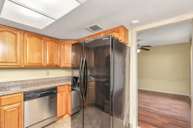 a kitchen with stainless steel appliances granite countertop a refrigerator and a stove top oven