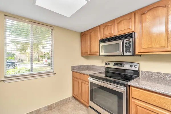a kitchen with granite countertop a stove microwave and sink