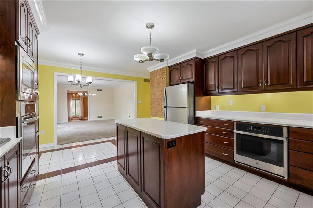 1001 Osage Road Pittsburgh, PA 15243 - Photo 17 of 42 a kitchen with kitchen island granite countertop a stove a sink dishwasher and a refrigerator with wooden floor