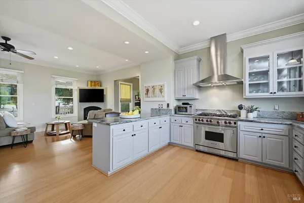 a large kitchen with stainless steel appliances granite countertop a stove and a wooden floors