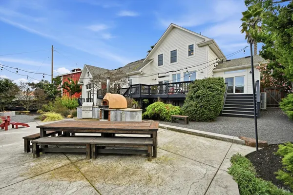 a backyard of a house with potted plants and outdoor seating