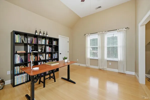 a view of a workspace with furniture and a bookshelf