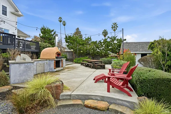 a backyard of a house with table and chairs potted plants and a swimming pool
