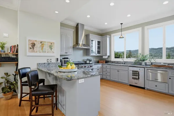 a kitchen with stainless steel appliances granite countertop a stove and white cabinets