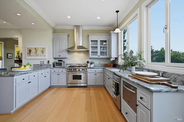 a kitchen with stainless steel appliances granite countertop a lot of counter space and wooden floors
