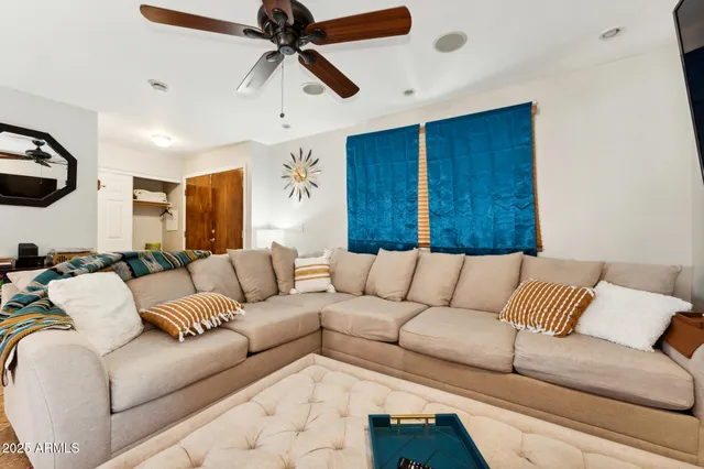 a living room with furniture and a ceiling fan