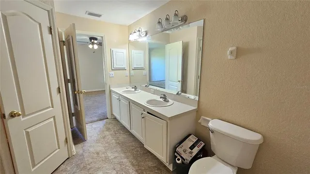 a bathroom with a sink a toilet a mirror and shower