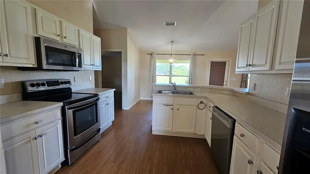 a kitchen with white cabinets stainless steel appliances and sink