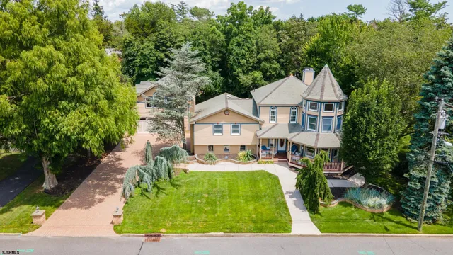 a front view of a house with a yard and trees