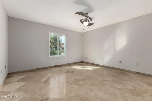 an empty room with closet and a ceiling fan
